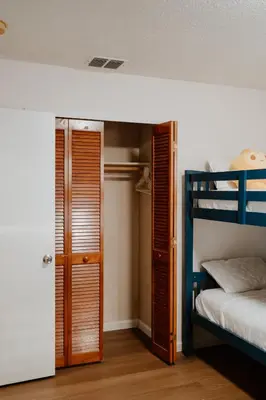a bedroom with two bunk beds and a closet at Luxury Private Pool Villa near Disney with Fire Pit, Game Room & More in Kissimmee