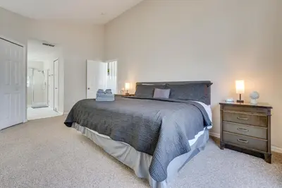a bedroom with a bed and a dresser with two lamps at 15 Mi to Universal Home with Pool in Kissimmee