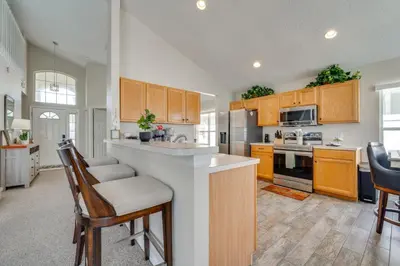 a kitchen with wooden cabinets and a counter top at 15 Mi to Universal Home with Pool in Kissimmee