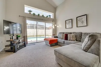 a living room with a couch and a tv at 15 Mi to Universal Home with Pool in Kissimmee