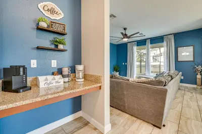 a living room with blue walls and a bar with a couch at Private Pool and Game Room Family Vacation Rental in Kissimmee