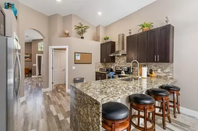 a kitchen with a large island with bar stools at Vacation Home near Disney World! in Kissimmee