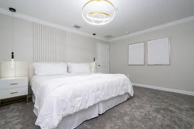 a white bedroom with a large bed and a lamp at Storey Lake 4Q/3B acesso Resort e Piscina Priv. in Kissimmee