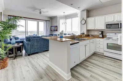 a kitchen with white cabinets and a blue couch at Disney Lakefront Luxury! in Orlando