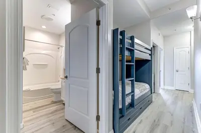 a bedroom with a bunk bed and a bathroom at Disney Lakefront Luxury! in Orlando