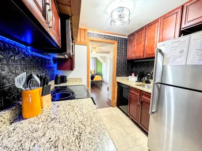 a kitchen with wooden cabinets and a stainless steel refrigerator at Hook's Cabin- Lake & Pool Near Disney A-frame in Clermont