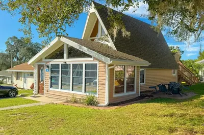a small house with a large window at Hook's Cabin- Lake & Pool Near Disney A-frame in Clermont