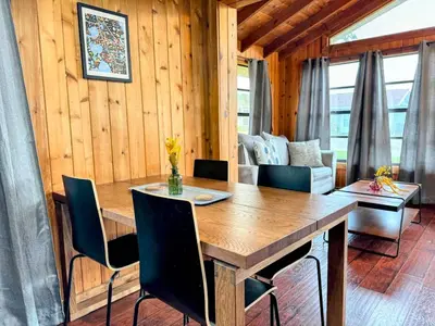 a dining room with a wooden table and chairs at Hook's Cabin- Lake & Pool Near Disney A-frame in Clermont