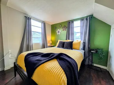 a bedroom with a large bed with a yellow blanket at Hook's Cabin- Lake & Pool Near Disney A-frame in Clermont
