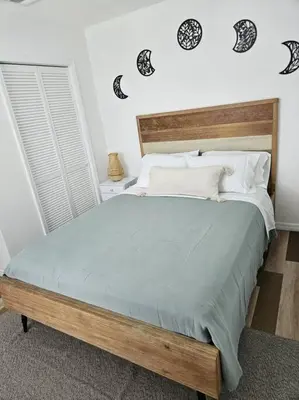 a bedroom with a large bed with a wooden headboard at Newly Renovated Modern Studio in Oviedo