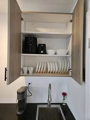 a kitchen with a sink and some bowls and cups at Newly Renovated Modern Studio in Oviedo