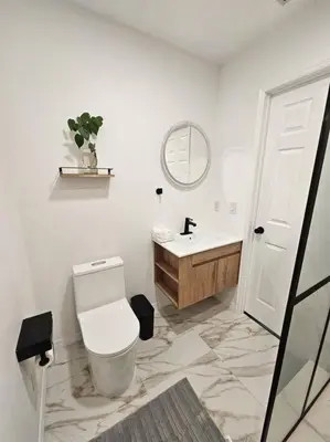 a white bathroom with a toilet and a sink at Newly Renovated Modern Studio in Oviedo