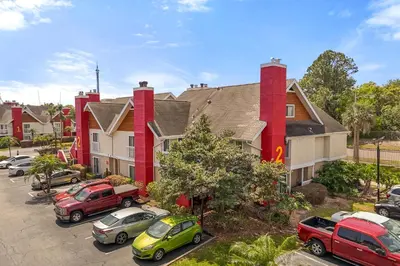 a group of houses with cars parked in a parking lot at Tranquil Haven 2BD 2BA Paradise 10min to Orlando's Best Theme Parks in Orlando