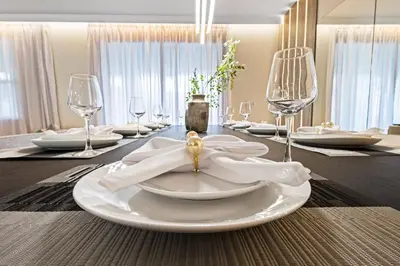 a dining table with white plates and wine glasses at 4561 Majestic 9BD Kingdom Retreat Near Disney in Kissimmee