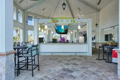 a restaurant with a counter with chairs and tables at Storey Lake Home: Pool, Gym, Lazy River & near Disney in Kissimmee