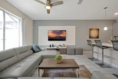 a living room with a couch and a table at Storey Lake Home: Pool, Gym, Lazy River & near Disney in Kissimmee