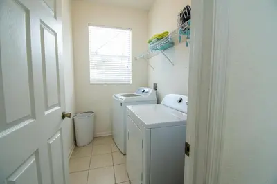 a white laundry room with a washer and dryer at Stunning 6 bedroom vacation villa in Orlando