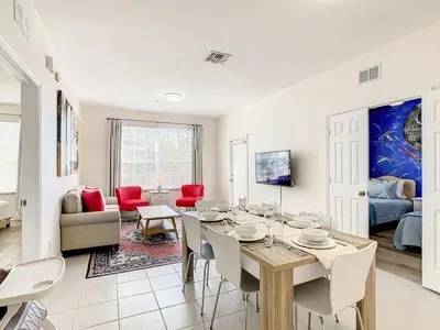 a dining room and living room with a table and chairs at Windsor Hills Luxury Condo, Pool,Slides, By Disney in Orlando
