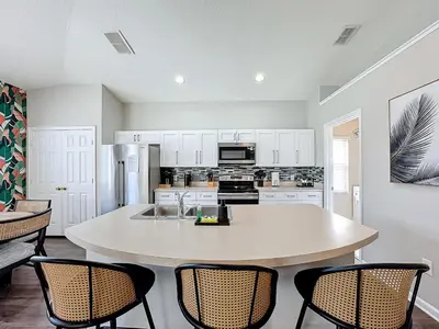 a kitchen with a table and chairs in a room at Windsor Palms Minion, Princess, Mickey, Pool Home in Kissimmee
