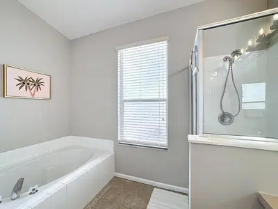 a white bathroom with a tub and a window at Windsor Palms Minion, Princess, Mickey, Pool Home in Kissimmee
