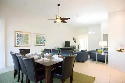 a dining room and living room with a table and chairs at Free Water Park 4BR wPool Game Room 7739TB in Orlando