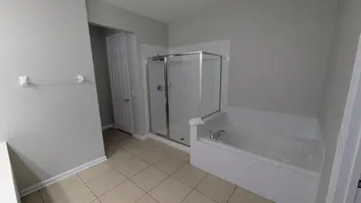 a white bathroom with a shower and a tub at 2BR Condo close Convention Center l Epic in Orlando