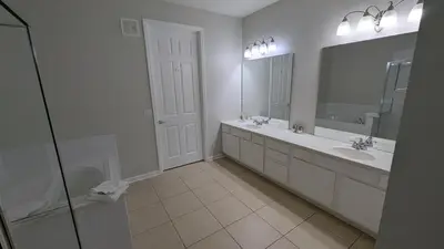 a white bathroom with two sinks and a mirror at 2BR Condo close Convention Center l Epic in Orlando