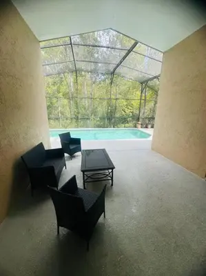 a patio with chairs and a table and a pool at Family Dream Home Near Disney in Kissimmee