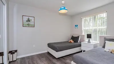 a bedroom with two beds and a window at Villas At Island Club Community, Pools, Jacuzzi And More! in Kissimmee