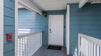 a blue house with a white door and a porch at Villas At Island Club Community, Pools, Jacuzzi And More! in Kissimmee