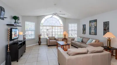 a living room with a couch and a tv at Villas At Island Club Community, Pools, Jacuzzi And More! in Kissimmee