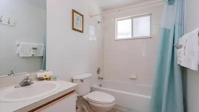 a white bathroom with a sink and a toilet and a tub at Villas At Island Club Community, Pools, Jacuzzi And More! in Kissimmee