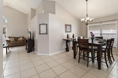 a dining room and living room with a table and chairs at Cozy Home Near Disney!!! in Kissimmee