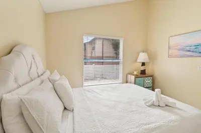 a bedroom with a white bed and a window at Cozy Home Near Disney!!! in Kissimmee