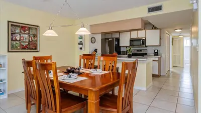 a kitchen and dining room with a wooden table and chairs at Villas At Island Club Community, Pools, Jacuzzi And More! in Kissimmee