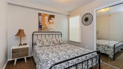 a bedroom with a bed and a dresser with a lamp at Villas At Island Club Community, Pools, Jacuzzi And More! in Kissimmee