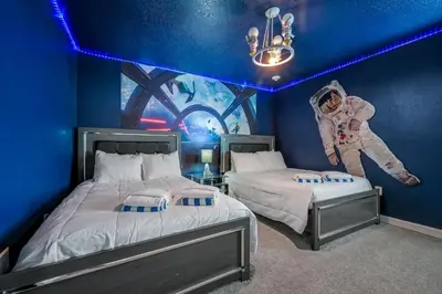 a room with two beds with an astronaut on the wall at Storey Lake Resort 1136 - Hosted by Top Villas in Kissimmee
