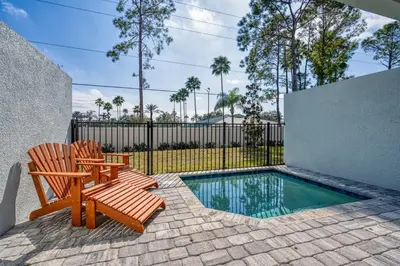 a patio with two chairs and a swimming pool at Formosa Valley Resort 61 - Hosted by Top Villas in Orlando