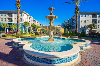 a fountain in a park with palm trees and buildings at Last Minute Disney Getaway Luxury Condo with Private Balcony. Book Now VC240 in Orlando