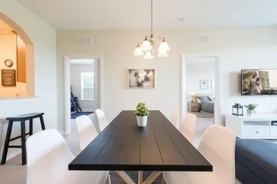 a dining room and living room with a table and chairs at Last Minute Disney Getaway Luxury Condo with Private Balcony. Book Now VC240 in Orlando