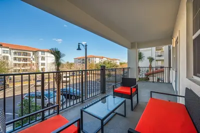 a balcony with tables and chairs and a view of a street at Vista Cay 239 - Hosted by Top Villas in Orlando