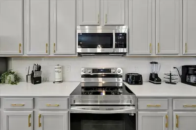 a kitchen with a stove and a microwave at Epic Orlando Mansion-Pool-Game Room-Theater-2 in Orlando