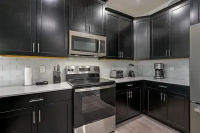 a kitchen with black cabinets and stainless steel appliances at Storey Lake Resort 1120 - Hosted by Top Villas in Kissimmee