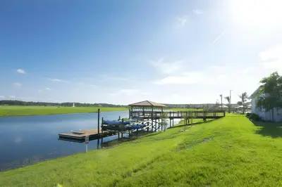 a house on the water with a dock at Beautiful 5bed home with Free Resort Access 4817 in Kissimmee