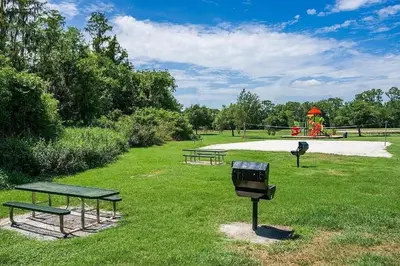 a park with two picnic tables and a playground at LB4701PL - 4 Beds villa - with pool and game room in Kissimmee