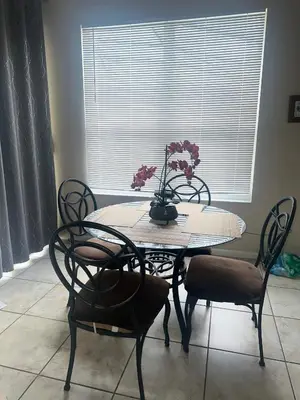 a table with chairs and a vase with flowers on it at Magical Home with private pool and close to parks in Kissimmee