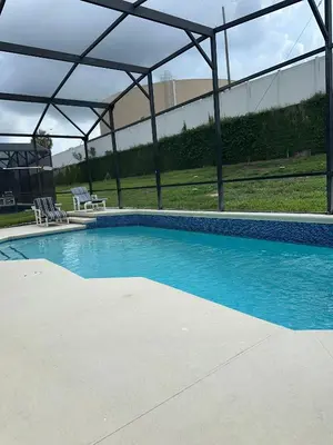 a large swimming pool with a canopy over it at Magical Home with private pool and close to parks in Kissimmee