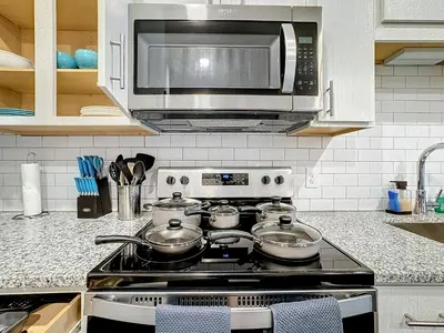 a kitchen with a stove top with a microwave at Luxury Apartments Near Disney in Orlando