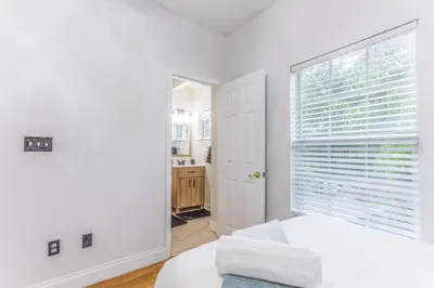 a white bedroom with a large window and a bed at Private Oasis near Springs with King Bd and Pool Table in Orlando