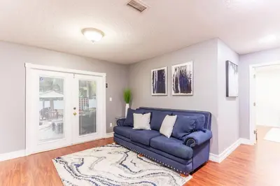 a living room with a blue couch and a rug at Private Oasis near Springs with King Bd and Pool Table in Orlando